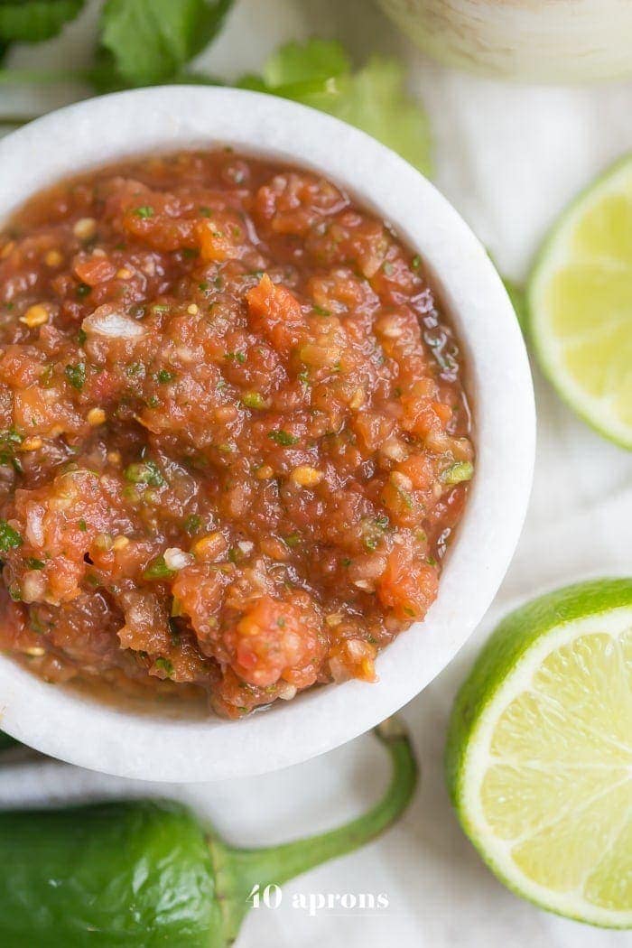 This is the best restaurant-style salsa recipe, and I've been making it blissfully for almost a decade! What makes this the best restaurant-style salsa recipe? Spoiler alert: it comes from one of my favorite Mexican restaurants (but I'll never say which)! It blends fresh garlic, cilantro, chiles, onions, and tomatoes with canned tomatoes for the perfect blend of fresh and traditional restaurant style salsa. So good!