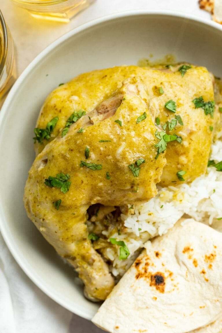 overhead image of green mole chicken on a plate with rice and a tortilla