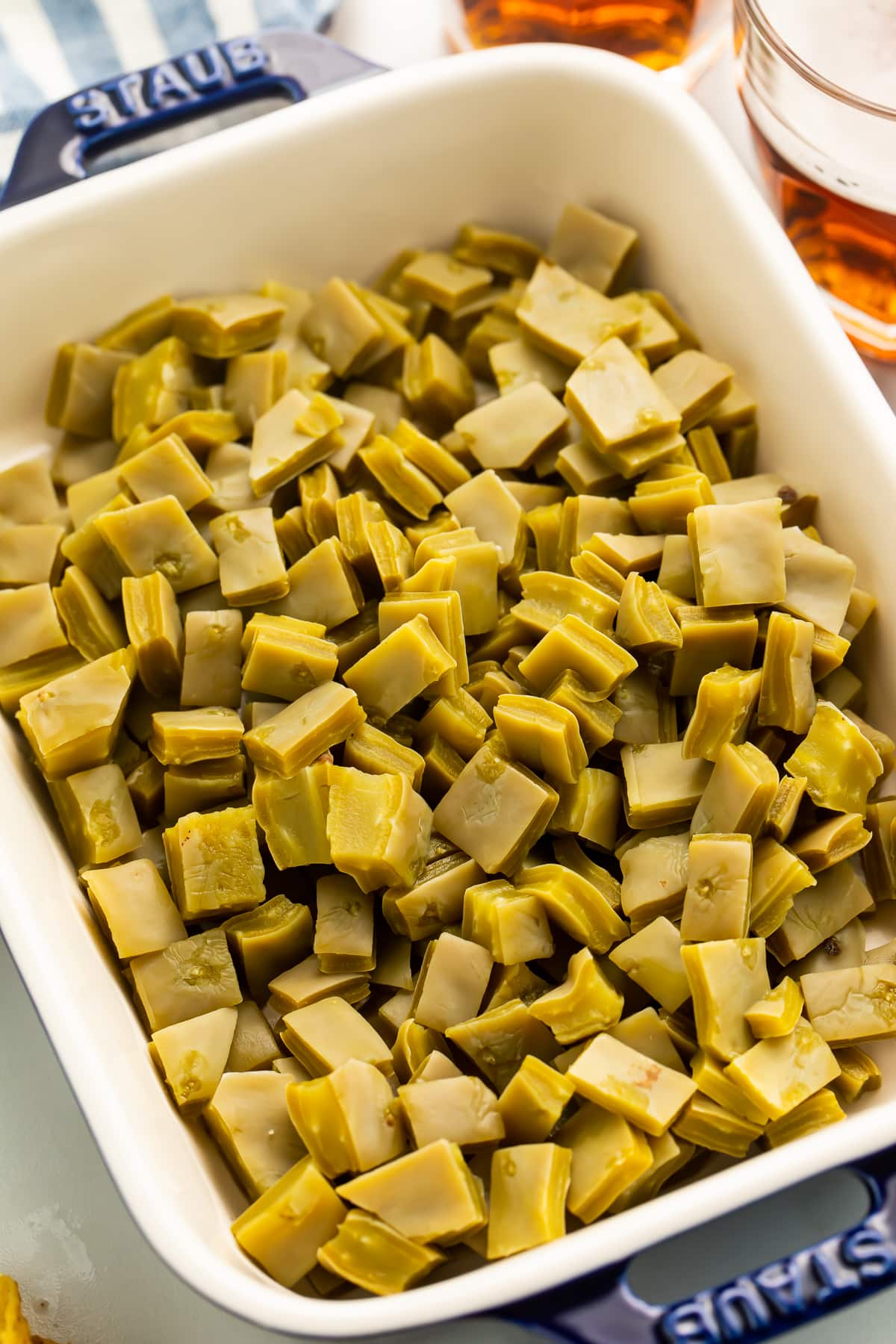 An overhead photo of a casserole dish filled with diced nopales. The dish sits at an angle on a table.