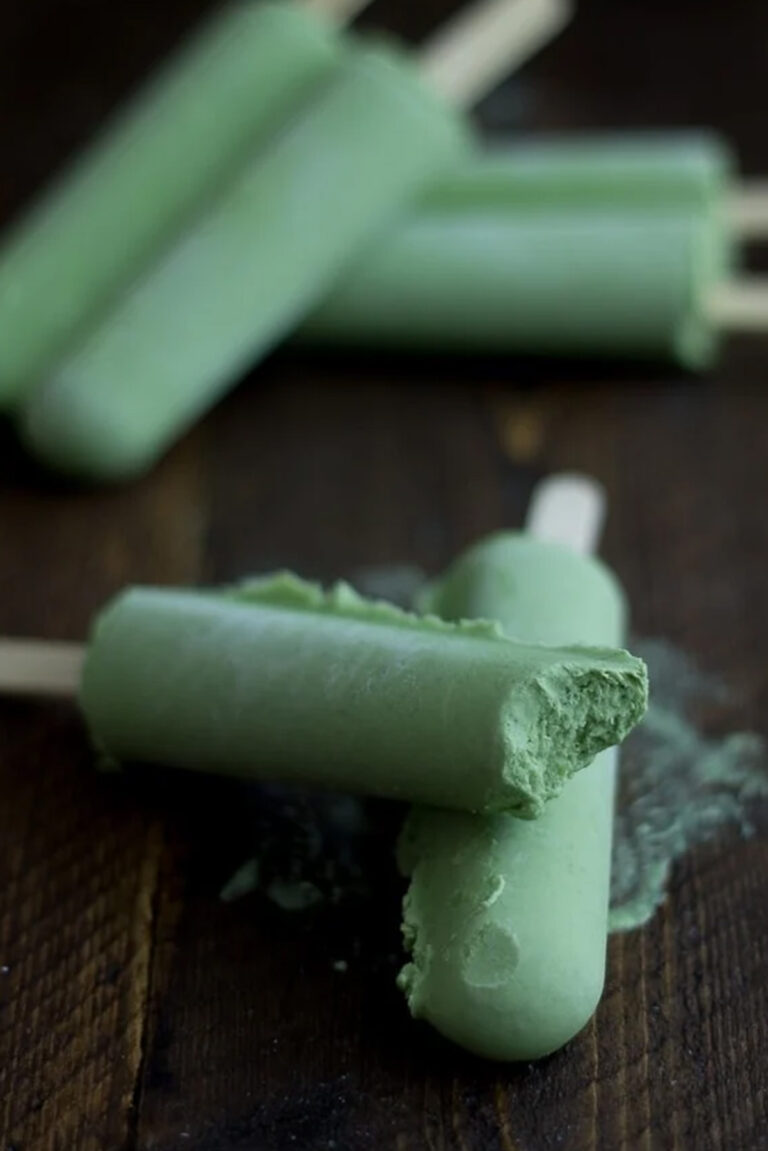 Green tea coconut popsicles, with one bite missing from a popsicle stacked on another popsicle.