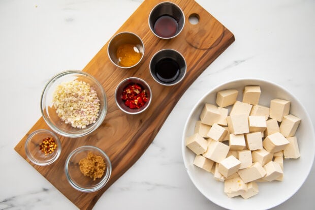 All ingredients for lemongrass tofu, with tofu in a large bowl