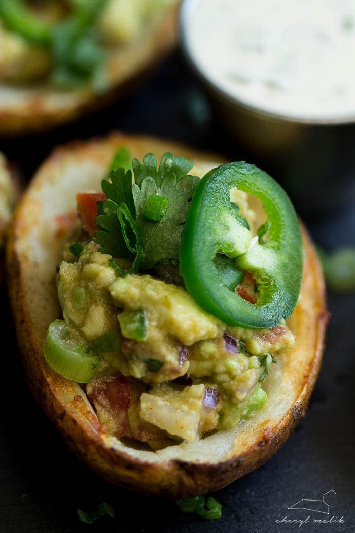 Vegan guacamole potato skins. Crispy potato skins topped with an incredibly flavorful, slightly smoky guacamole. Perfect for tailgating!