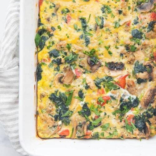 Whole30 breakfast casserole with sausage, spinach, and mushrooms in a baking dish