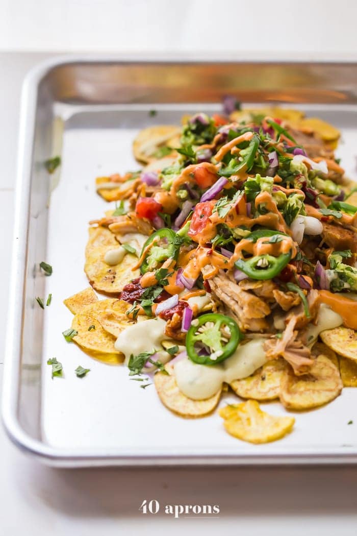 These paleo nachos are epic, aka the best paleo nachos ever. What makes paleo nachos epic, you ask? Well, what do you think of plantain chips topped with tender carnitas, the best paleo queso blanco, guacamole, pico de gallo, smoky guajillo salsa, and creamy chipotle sauce? If those doesn't sound like the best paleo nachos to you, I just don't even know who you are anymore. 