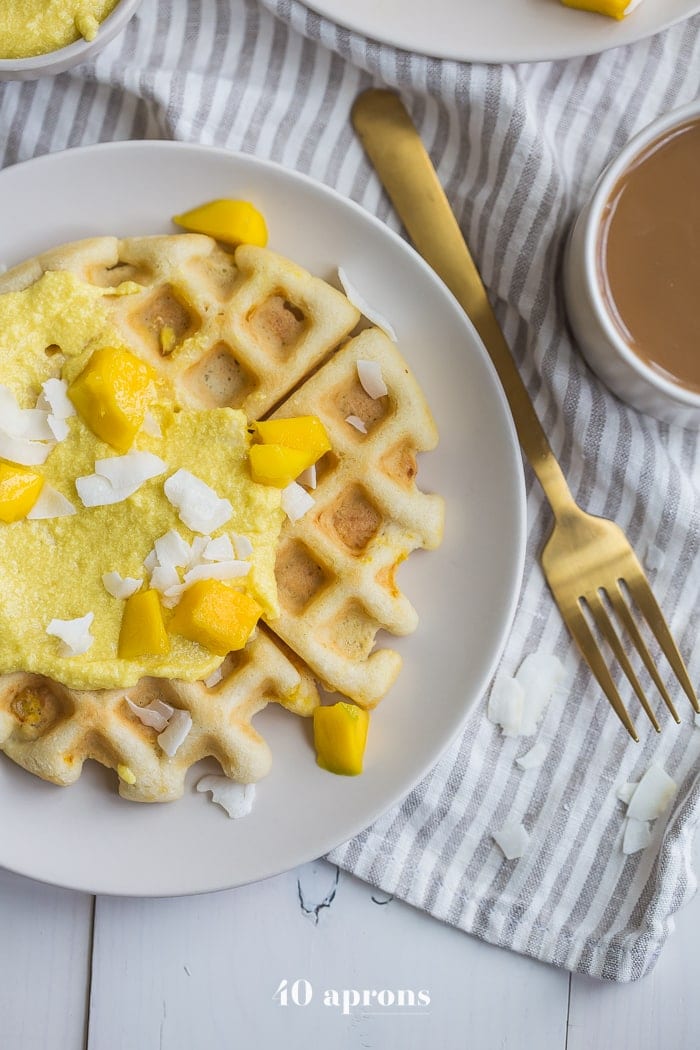 These are the best paleo waffles, topped with sweet mango cream. They're tender and light, sweet and flavorful. Topped with a sweet mango cream made from healthy, real ingredients, this dish will become your favorite paleo breakfast recipe! And if you're asking me, this is the best paleo waffle recipe - the texture is light and fluffy, but you'll feel energized instead of sluggish after a stack. Perfect for spring and summer!