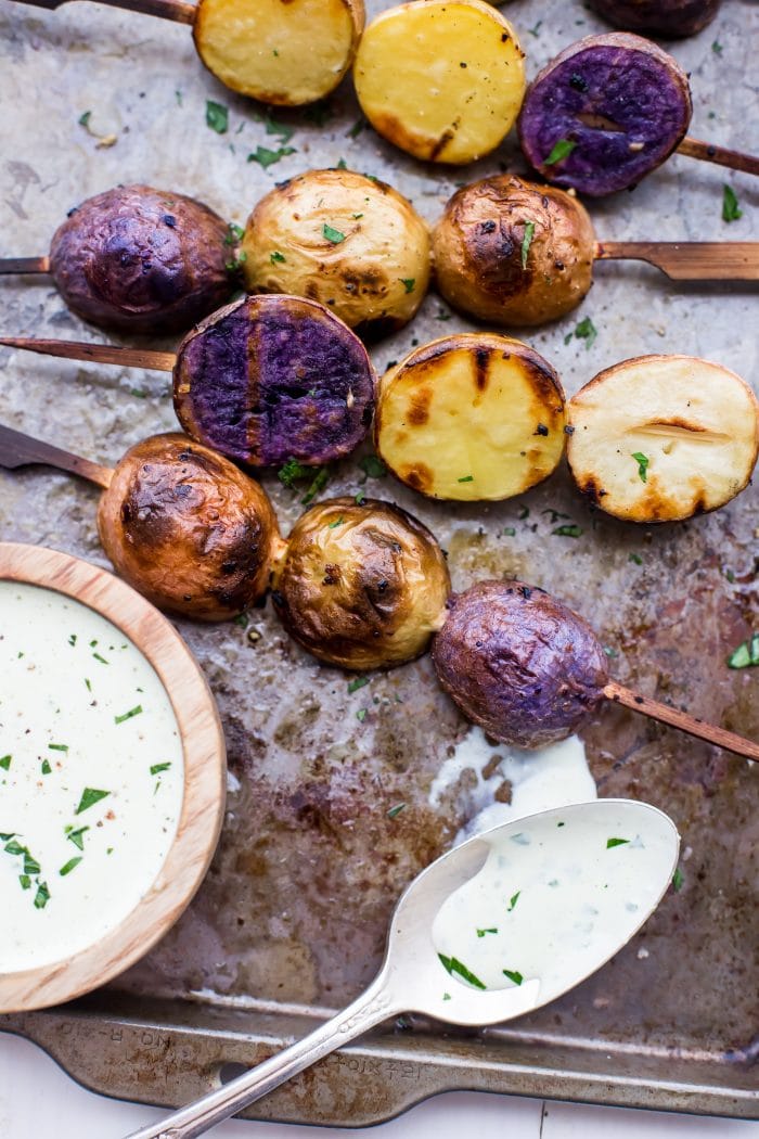 One of the best red, white, and blue side dishes! These grilled red, white, and blue potato skewers with ranch dressing are the perfect patriotic side dish. Garlicky, packed with flavor, and festive yet elegant, they go so well with burgers or brauts on the grill! One of the best red, white, and blue side dishes, these Whole30 potato skewers with ranch dressing are just delicious.