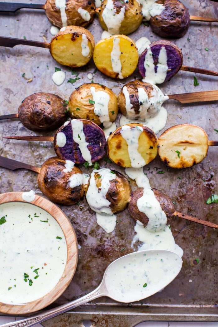 One of the best red, white, and blue side dishes! These grilled red, white, and blue potato skewers with ranch dressing are the perfect patriotic side dish. Garlicky, packed with flavor, and festive yet elegant, they go so well with burgers or brauts on the grill! One of the best red, white, and blue side dishes, these Whole30 potato skewers with ranch dressing are just delicious.