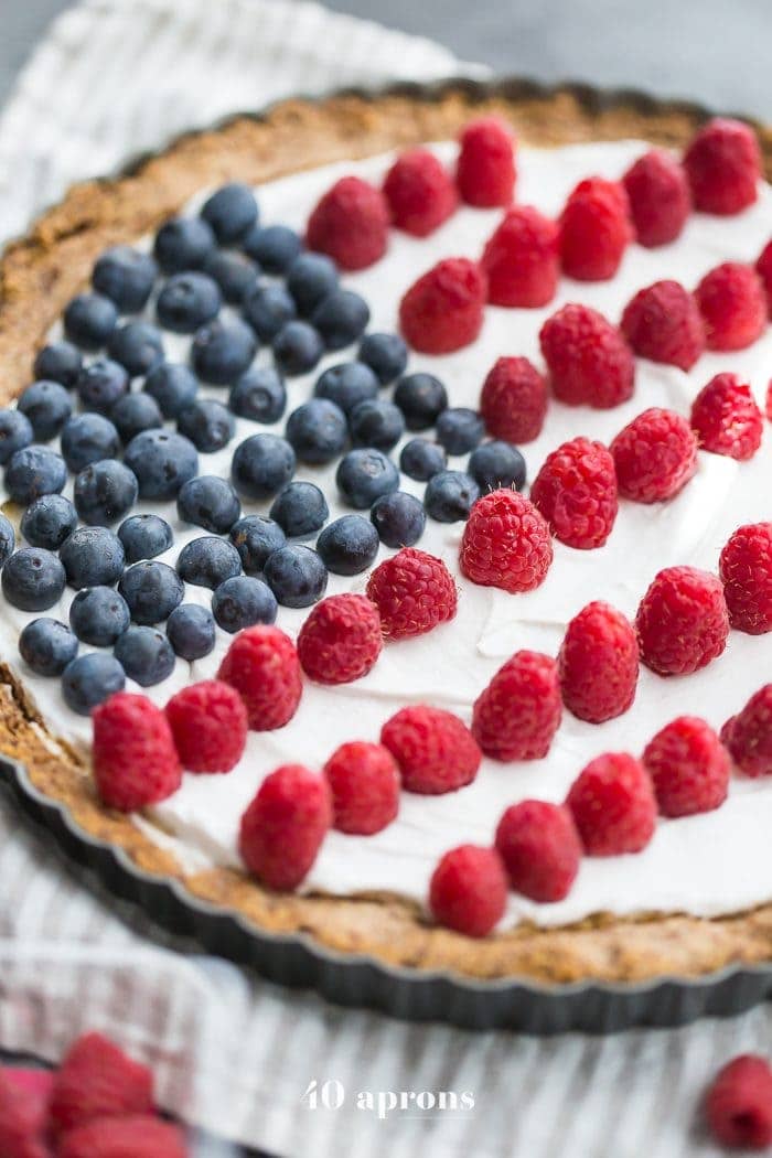 This paleo flag fruit tart is Fourth of July dessert perfection. With a coconut oil shortbread crust, rich almond frangiapane filling, and topped with cool coconut cream and fresh fruit, you've got your paleo Fourth of July dessert covered. Why make a paleo 4th of July cake when you can make a tart delicious enough to beat all other paleo 4th of July desserts?! U-S-A! U-S-A!