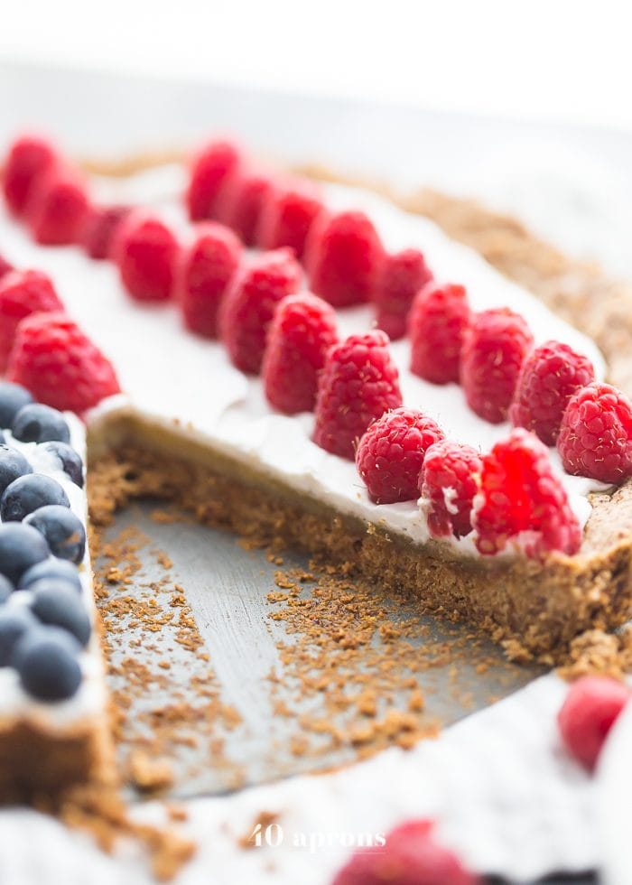 This paleo flag fruit tart is Fourth of July dessert perfection. With a coconut oil shortbread crust, rich almond frangiapane filling, and topped with cool coconut cream and fresh fruit, you've got your paleo Fourth of July dessert covered. Why make a paleo 4th of July cake when you can make a tart delicious enough to beat all other paleo 4th of July desserts?! U-S-A! U-S-A!