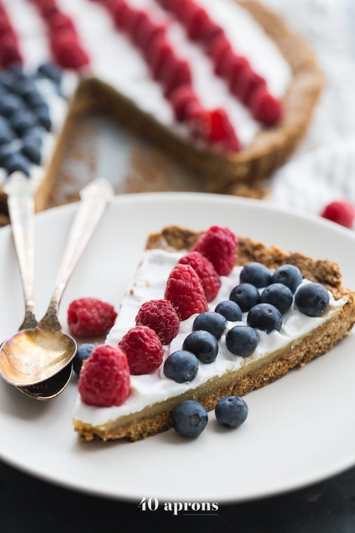 This paleo flag fruit tart is Fourth of July dessert perfection. With a coconut oil shortbread crust, rich almond frangiapane filling, and topped with cool coconut cream and fresh fruit, you've got your paleo Fourth of July dessert covered. Why make a paleo 4th of July cake when you can make a tart delicious enough to beat all other paleo 4th of July desserts?! U-S-A! U-S-A!