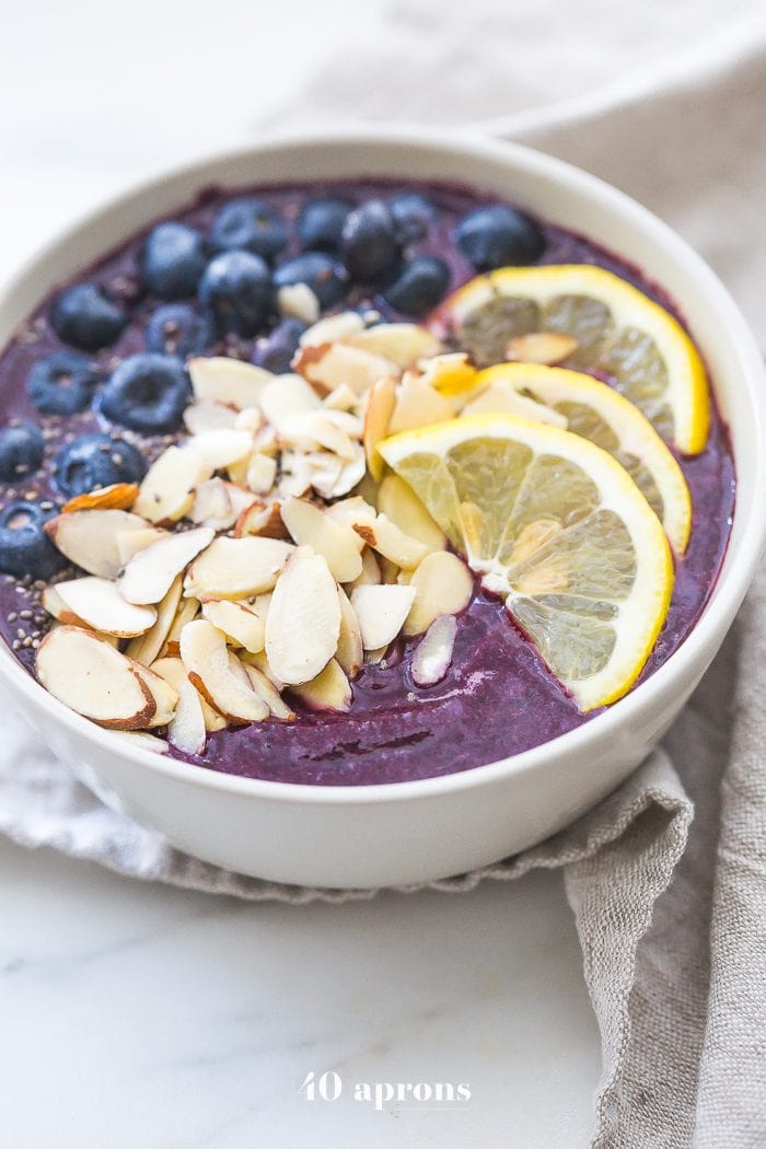 This blueberry muffin smoothie bowl is sweet with a touch of lemon and vanilla, just like a blueberry muffin! This blueberry smoothie bowl takes only 5 minutes and is paleo and vegan. With only 5 ingredients, you'll get addicted to this blueberry muffin smoothie bowl!