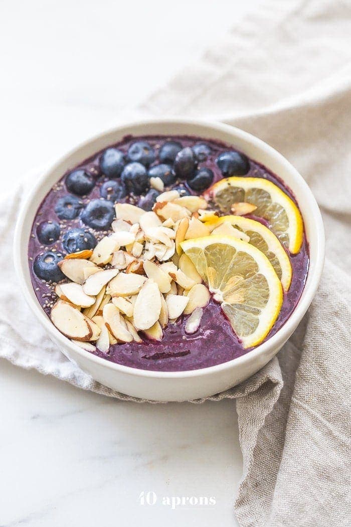 This blueberry muffin smoothie bowl is sweet with a touch of lemon and vanilla, just like a blueberry muffin! This blueberry smoothie bowl takes only 5 minutes and is paleo and vegan. With only 5 ingredients, you'll get addicted to this blueberry muffin smoothie bowl!