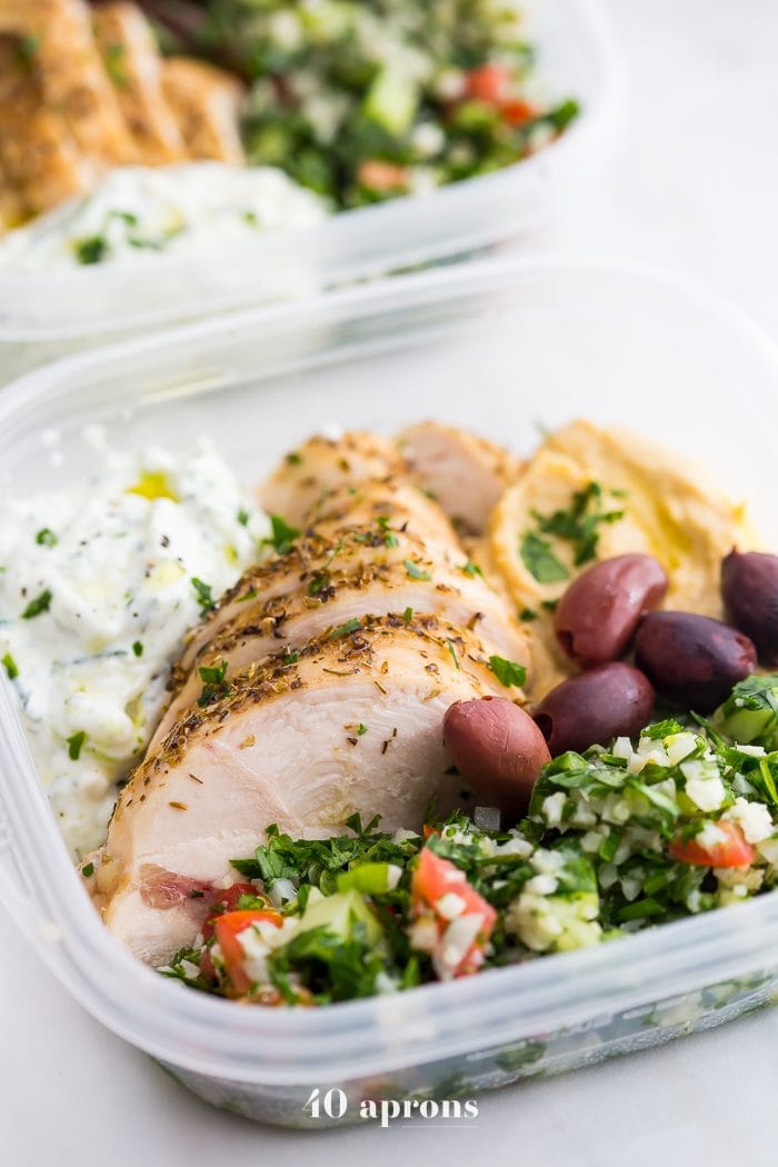 This Greek healthy meal prep recipe is epic: cauliflower rice tabbouleh, tender seasoned chicken breasts, hummus or baba ganoush, kalamata olives, and a rich, garlicky tzatziki. This healthy meal prep recipe will have you looking forward to lunch all morning! It's also a Whole30 meal prep recipe and paleo meal prep recipe, too, when you sub coconut cream or coconut yogurt for the yogurt. This is seriously SUCH a perfect healthy meal prep recipe.