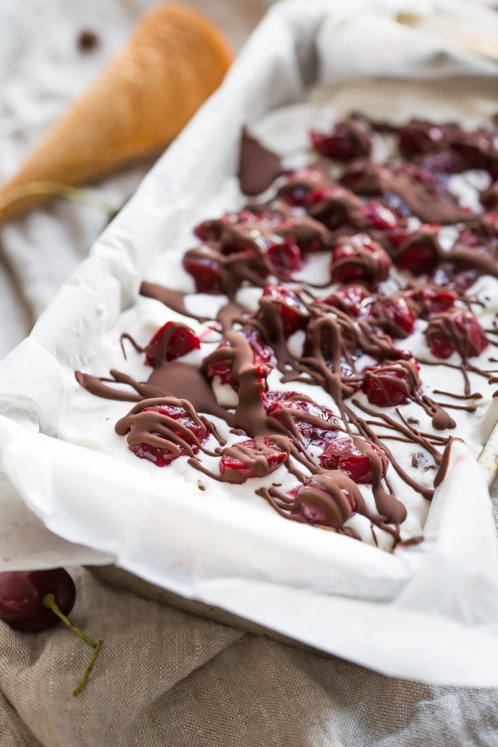 This paleo chocolate chip ice cream with roasted cherries is easy, rich, a bit tart, and totally delicious. With a vegan chocolate chip ice cream base, inspired by Italian stracciatella, it layers heady, roasted cherries, producing the perfect creamy, tart, chocolatey combination. Such a fantastic paleo ice cream recipe (or vegan ice cream recipe, if you prefer!). You absolutely must try this paleo chocolate chip ice cream with roasted cherries while the fruit is still in season.