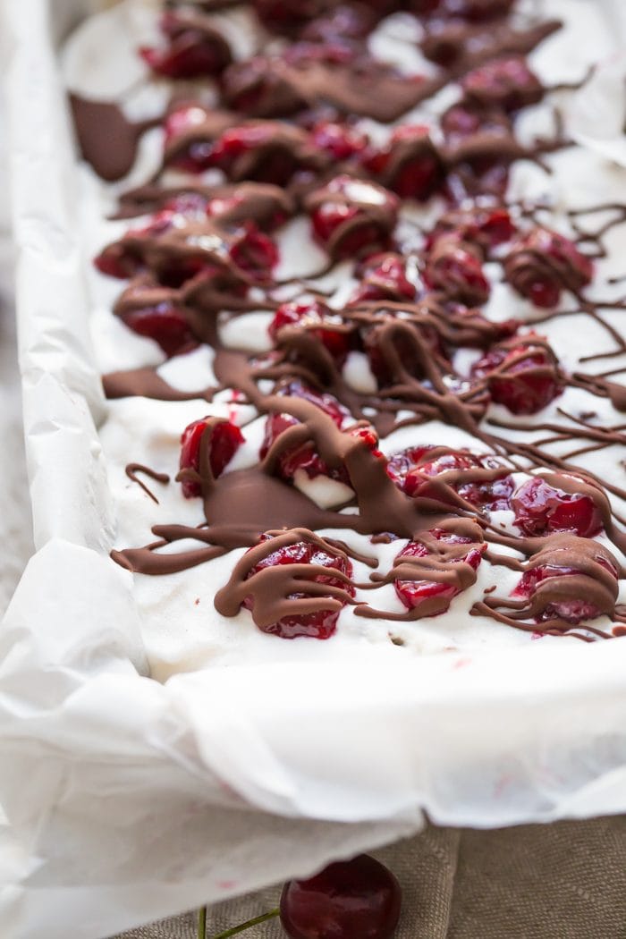 This paleo chocolate chip ice cream with roasted cherries is easy, rich, a bit tart, and totally delicious. With a vegan chocolate chip ice cream base, inspired by Italian stracciatella, it layers heady, roasted cherries, producing the perfect creamy, tart, chocolatey combination. Such a fantastic paleo ice cream recipe (or vegan ice cream recipe, if you prefer!). You absolutely must try this paleo chocolate chip ice cream with roasted cherries while the fruit is still in season.