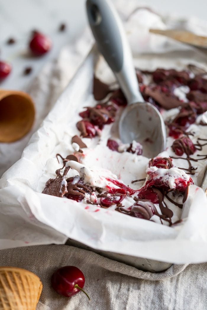 This paleo chocolate chip ice cream with roasted cherries is easy, rich, a bit tart, and totally delicious. With a vegan chocolate chip ice cream base, inspired by Italian stracciatella, it layers heady, roasted cherries, producing the perfect creamy, tart, chocolatey combination. Such a fantastic paleo ice cream recipe (or vegan ice cream recipe, if you prefer!). You absolutely must try this paleo chocolate chip ice cream with roasted cherries while the fruit is still in season.