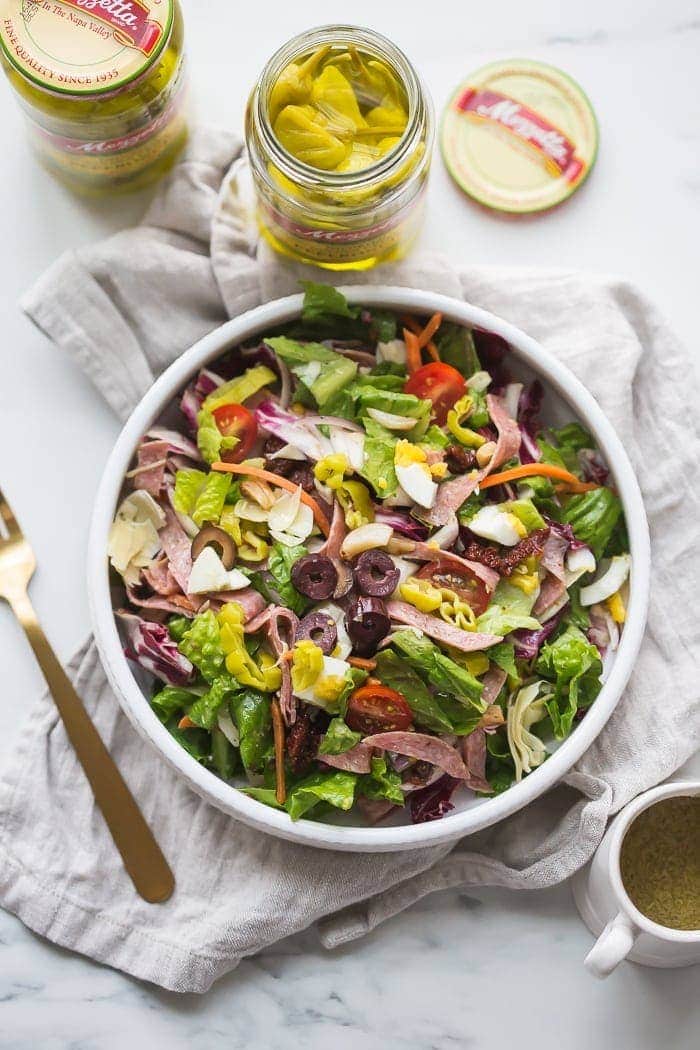 This paleo Italian salad is one of my very favorite paleo salads: loaded with radicchio, roasted garlic, olives, bright and spicy peperoncinis, salami, sun-dried tomatoes, and more. Such a great paleo dinner, paleo salad, or paleo side dish! Seriously, this paleo Italian salad will become a staple in your meal plan.