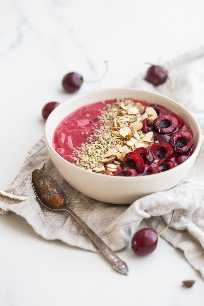 This cherry smoothie bowl is so bright and refreshing yet totally filling. With only a handful of ingredients, this cherry smoothie bowl comes together in just a few minutes. This vegan smoothie bowl is perfect for the spring or summer and will keep you full for hours! Such a fantastic paleo smoothie bowl, too. It tastes so much like cherry pie: the vanilla extract really makes it!