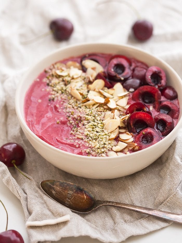 This cherry smoothie bowl is so bright and refreshing yet totally filling. With only a handful of ingredients, this cherry smoothie bowl comes together in just a few minutes. This vegan smoothie bowl is perfect for the spring or summer and will keep you full for hours! Such a fantastic paleo smoothie bowl, too. It tastes so much like cherry pie: the vanilla extract really makes it!