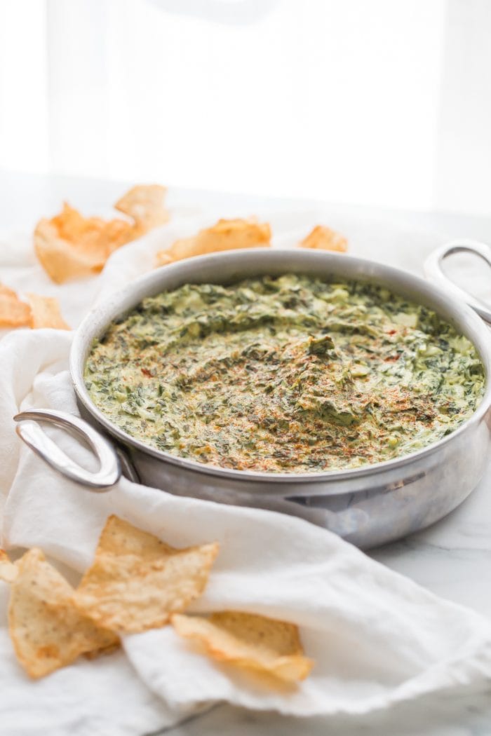 This paleo spinach artichoke dip is a healthy take on the classic appetizer. Rich and creamy, this vegan spinach artichoke dip is the perfect recipe for casual entertaining, especially in late summer and early fall. This paleo spinach artichoke dip is dairy free and goes perfectly with some paleo tortilla chips! One of my very favorite paleo appetizers, it really doesn't taste paleo!