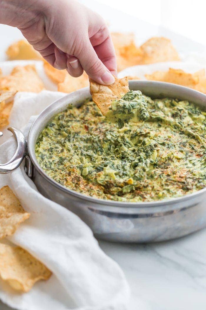 This paleo spinach artichoke dip is a healthy take on the classic appetizer. Rich and creamy, this vegan spinach artichoke dip is the perfect recipe for casual entertaining, especially in late summer and early fall. This paleo spinach artichoke dip is dairy free and goes perfectly with some paleo tortilla chips! One of my very favorite paleo appetizers, it really doesn't taste paleo!