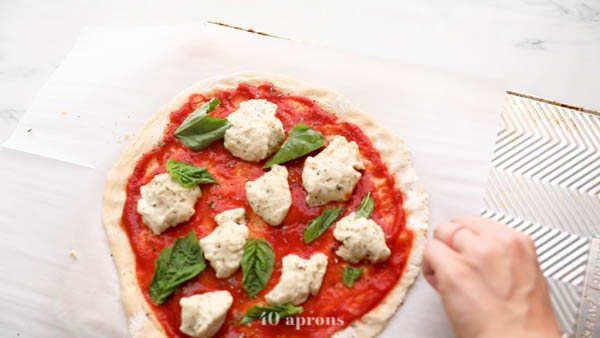 Slide prepared pizza onto overturned baking sheet