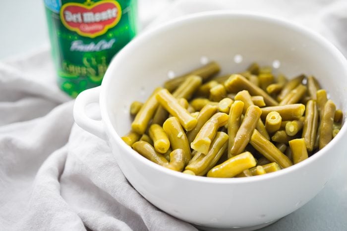 Whole30 Del Monte green beans with bacon in a white dish