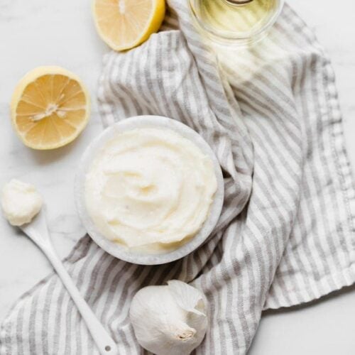 hole30 coconut oil mayonnaise in a bowl with lemons, garlic, and coconut oil