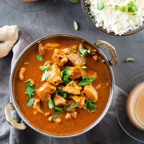 Indian butter chicken in a bowl with cauliflower rice and chai tea