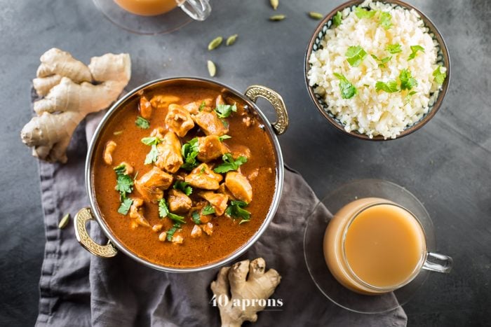 Whole30 Indian butter chicken in a bowl with cauliflower rice and chai tea