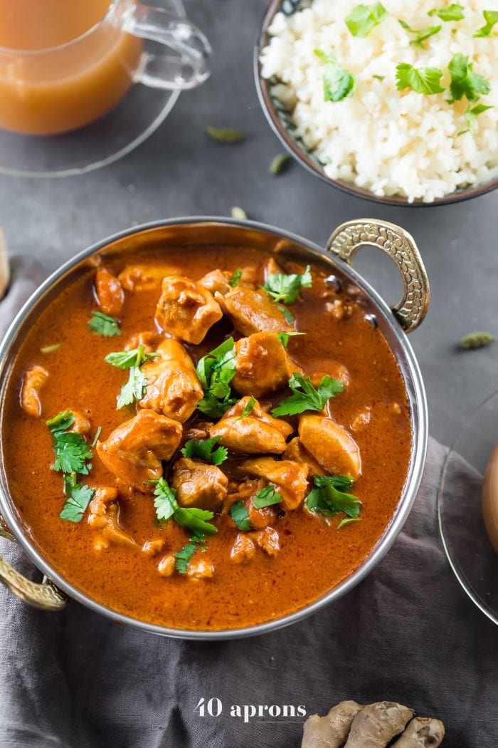 Indian butter chicken in a bowl with cauliflower rice and chai tea