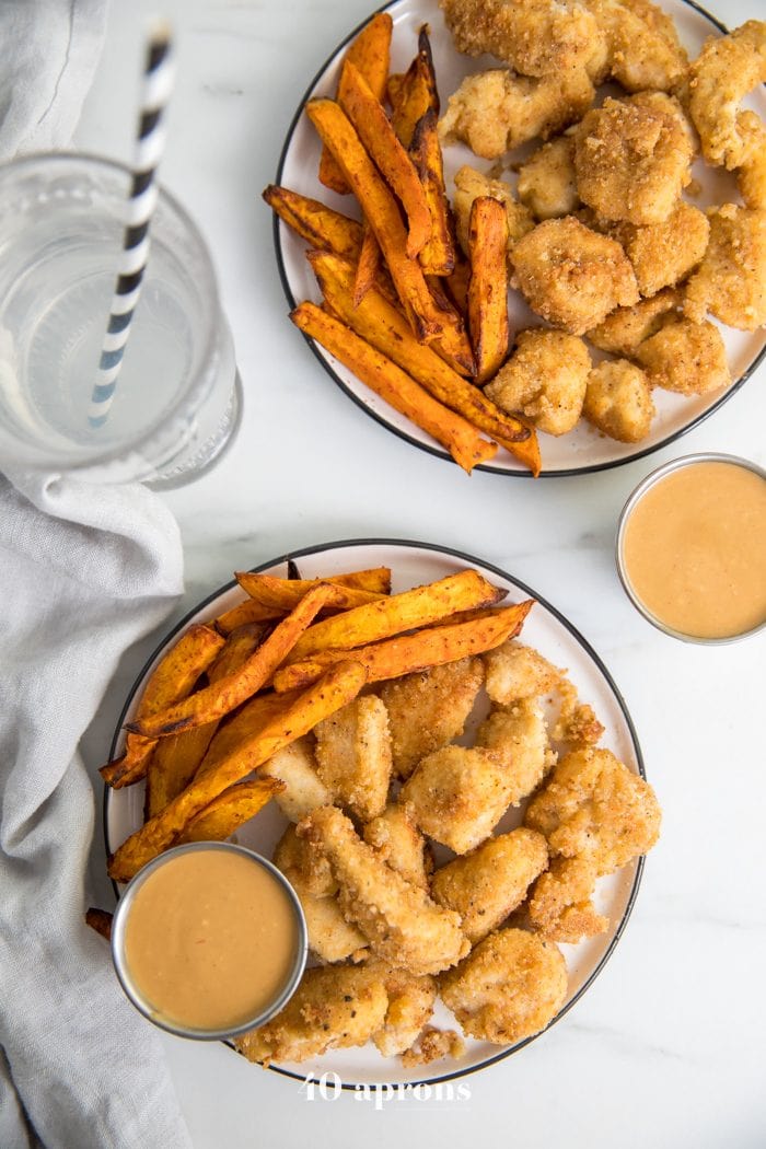 Paleo Whole30 chicken nuggets recipe on a plate with dipping sauce sauce and sweet potato fries