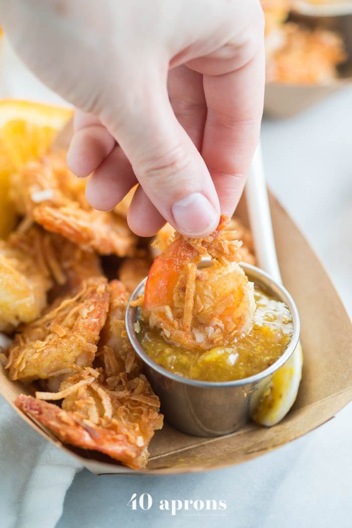 Whole30 coconut shrimp with orange sauce in a container