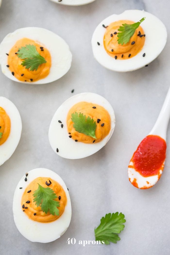 Whole30 sriracha deviled eggs with a spoon of Whole30 sriracha