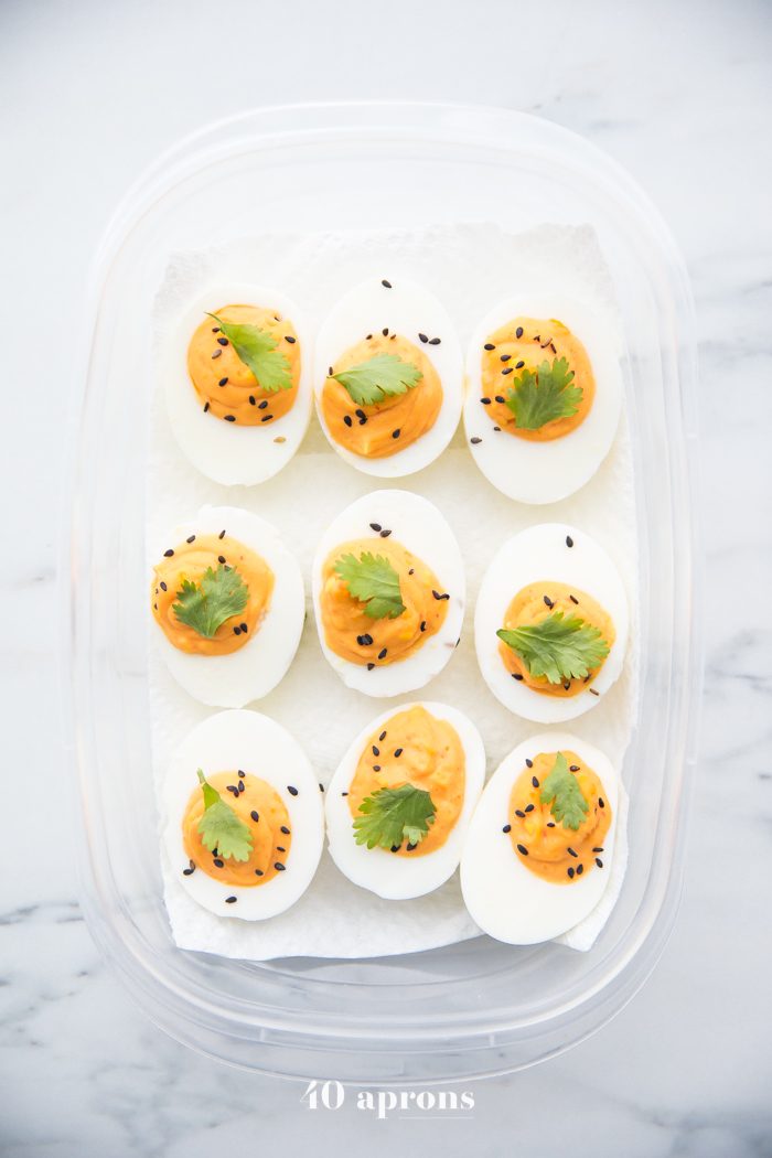 Sriracha deviled eggs in a plastic container