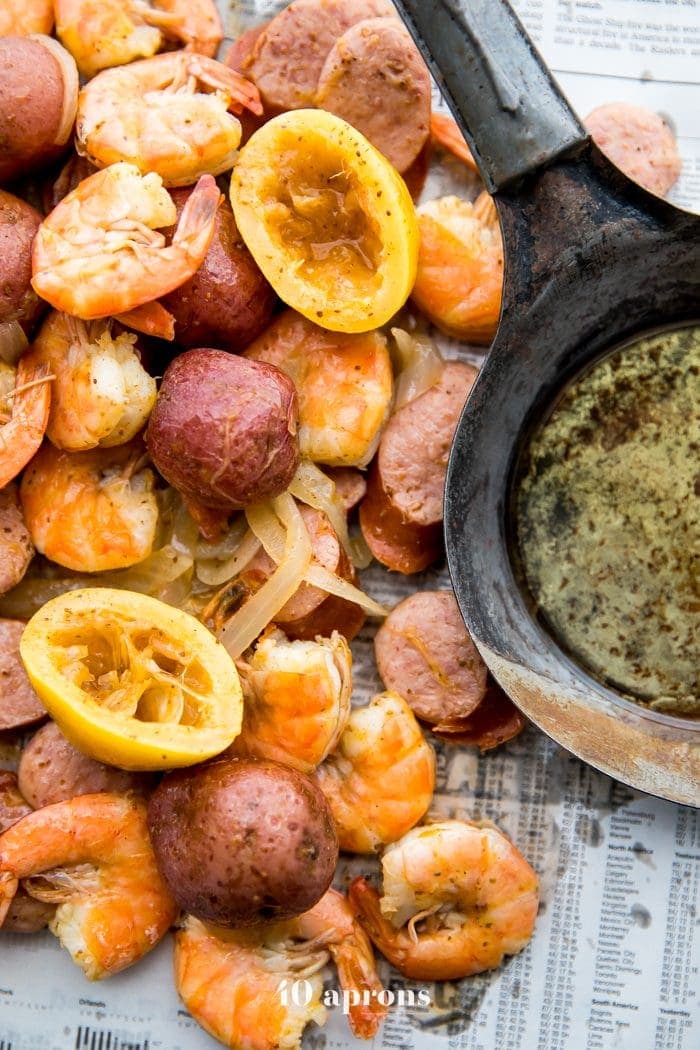 Whole30 shrimp boil with sausage, potatoes, and garlic ghee on newspaper