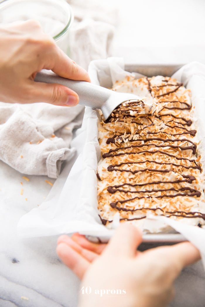 Hand scooping Samoas cookies ice cream with ice cream scoop