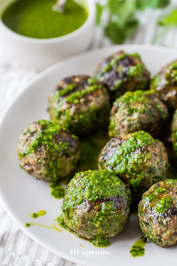 Chimichurri Whole30 meatballs with swiss chard on a white plate