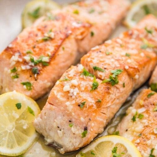 Lemon garlic salmon in a skillet with lemon slices