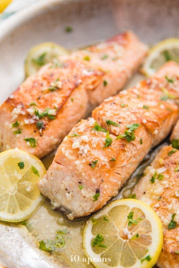 Lemon garlic salmon in a skillet with lemon slices