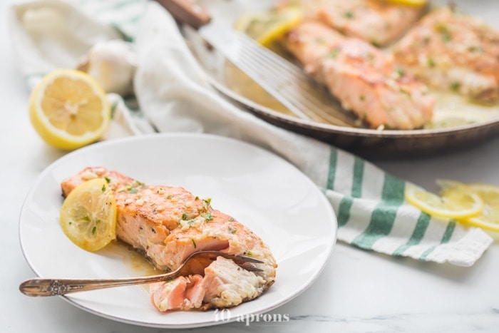 Lemon garlic salmon in a skillet with lemon slices