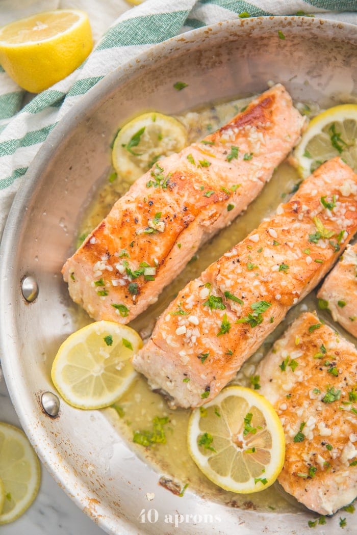 Lemon garlic salmon in a skillet with lemon slices