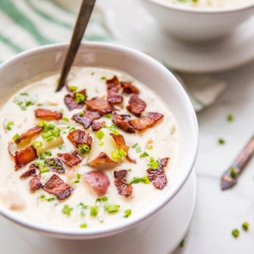 Close up of healthy creamy Whole30 clam chowder in two bowls with bacon and chives