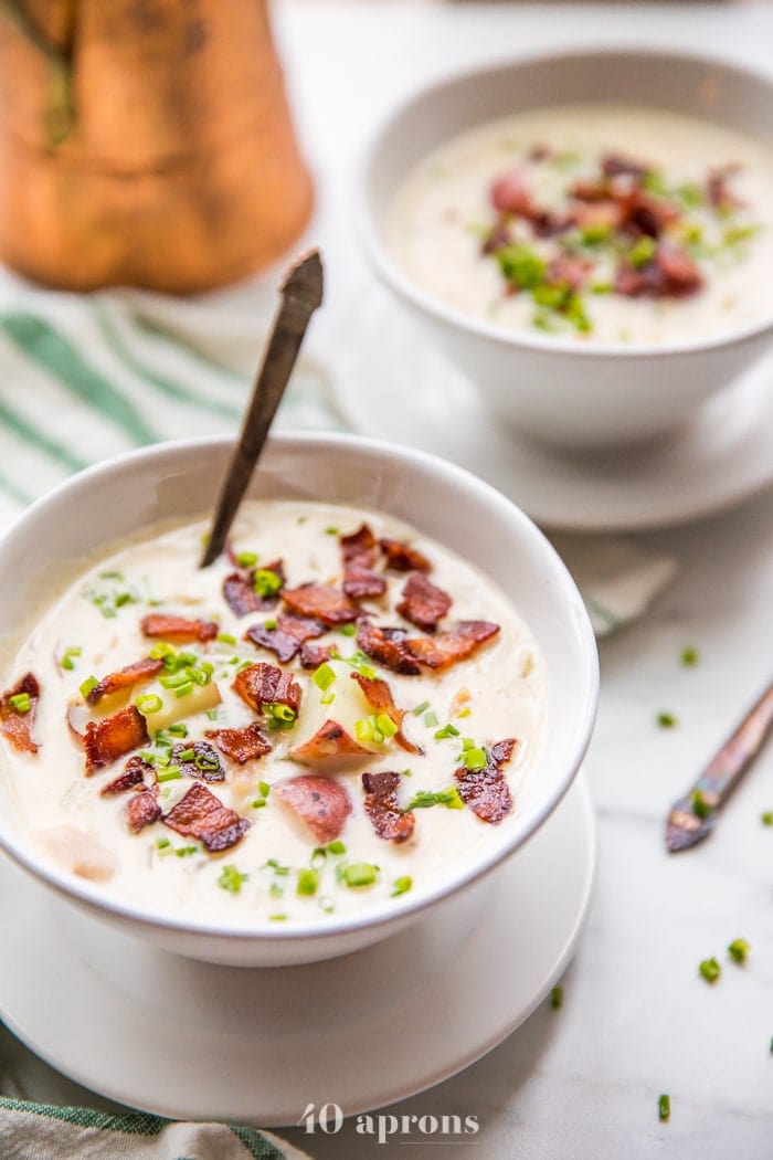 Close up of healthy creamy Whole30 clam chowder in two bowls with bacon and chives