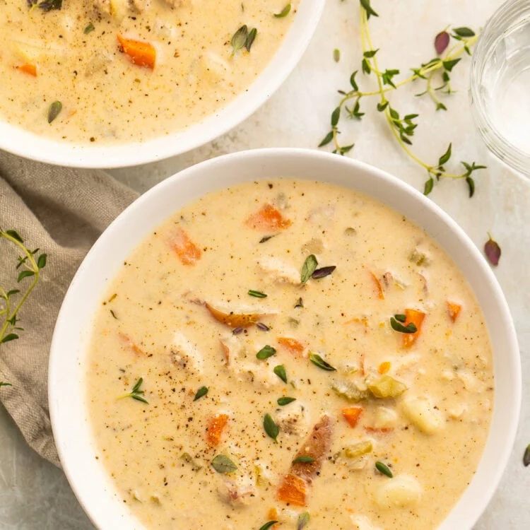 A white soup bowl, holding a creamy chicken pot pie soup made in the Instant Pot.