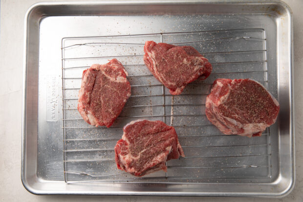 Raw filet mignon on a wire cooling rack