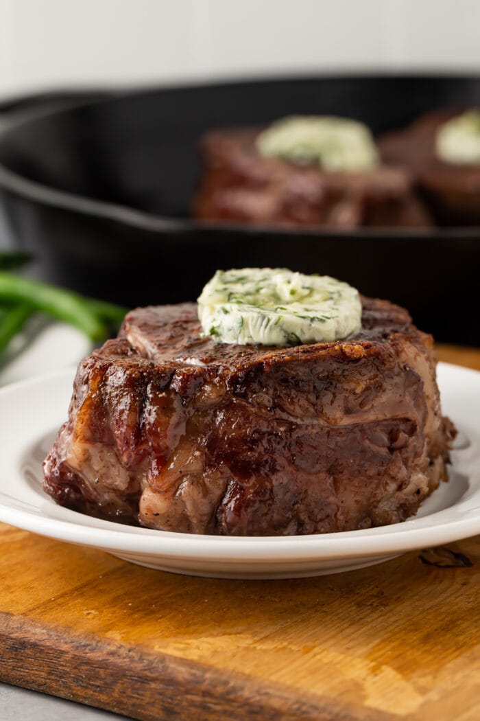 Side view of plated filet mignon topped with garlic herb butter