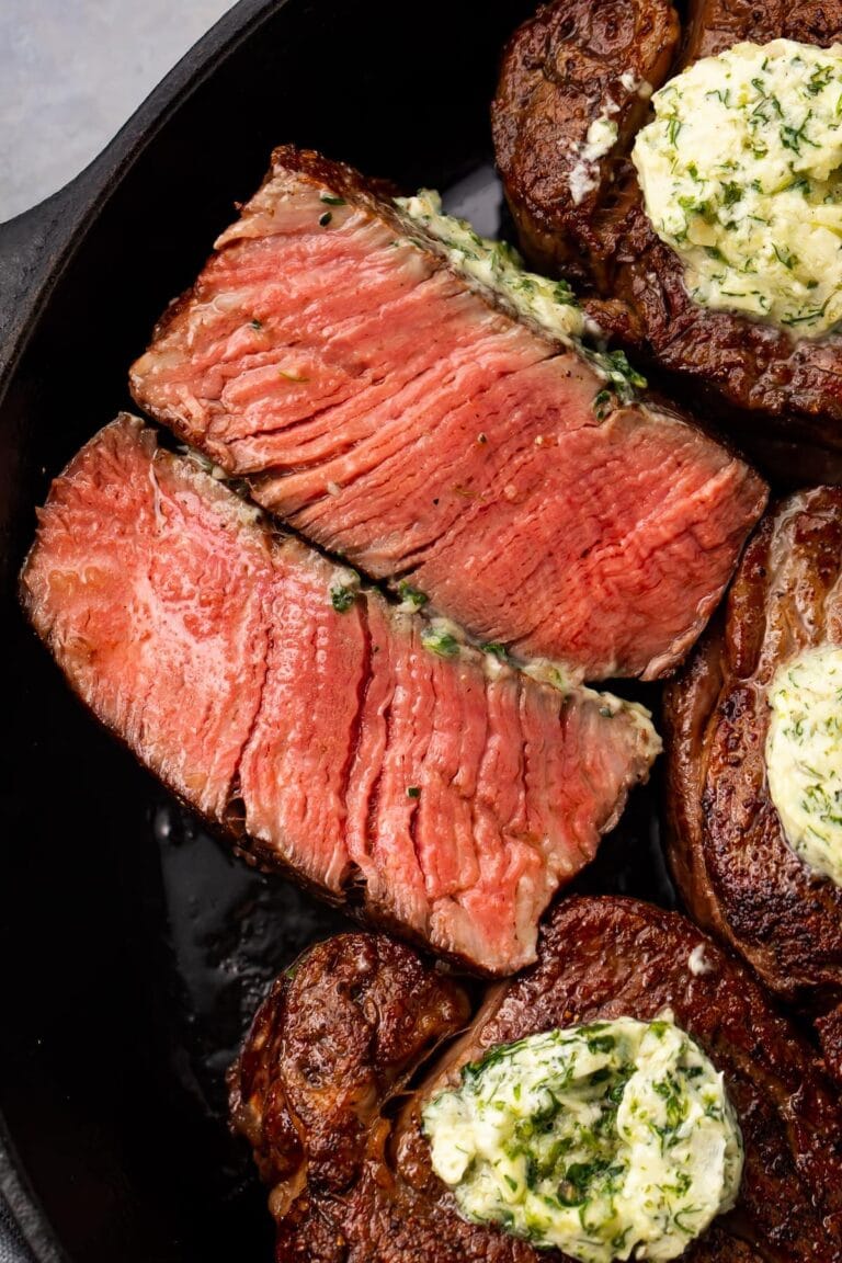 Close up of sliced medium rare filet mignon in a cast-iron skillet