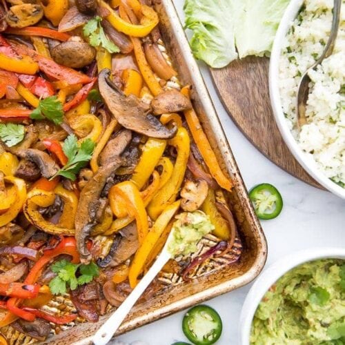 Overhead of Vegetarian sheet pan fajitas with a bowl of cauliflower rice and bowl of guacamole to the side