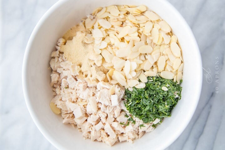 Overhead view of ingredients for tarragon chicken salad in a large mixing bowl.